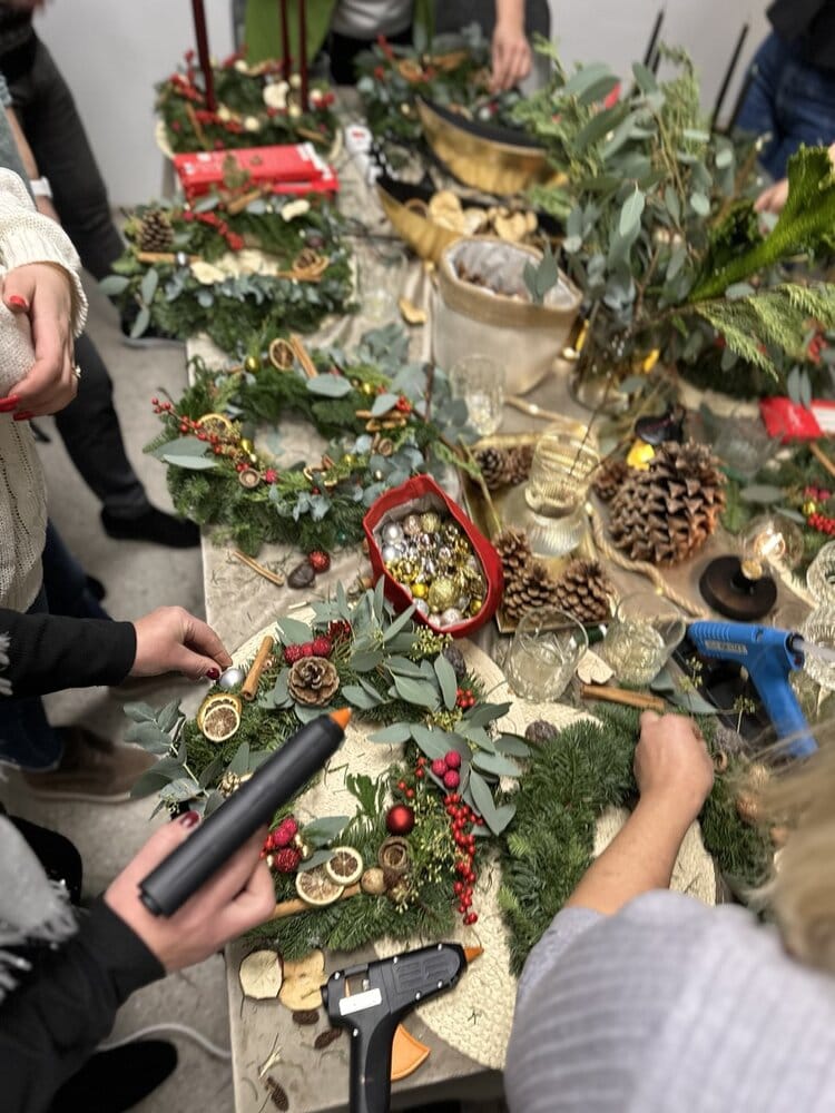 Šventinio dekoravimo dirbtuvės, kuriose žmonės kuria žiemos ir Kalėdų vainikus, naudojant įvairius spygliuočius, adatą, kaštonus, vakarines uogas ir dekoro elementus, siekiant sukurti jaukią šventinę atmosferą.